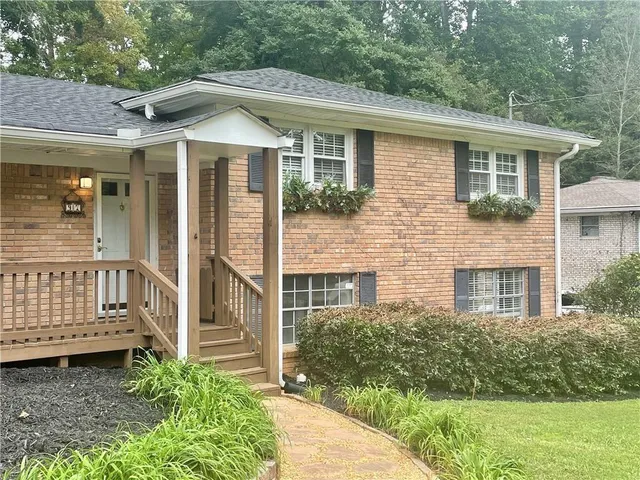 a view of a house with a small yard and a large window and wooden fence