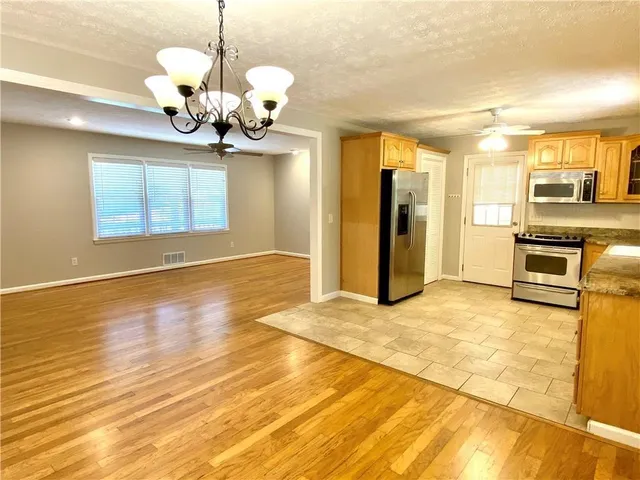 a view of a livingroom with a chandelier furniture and windows