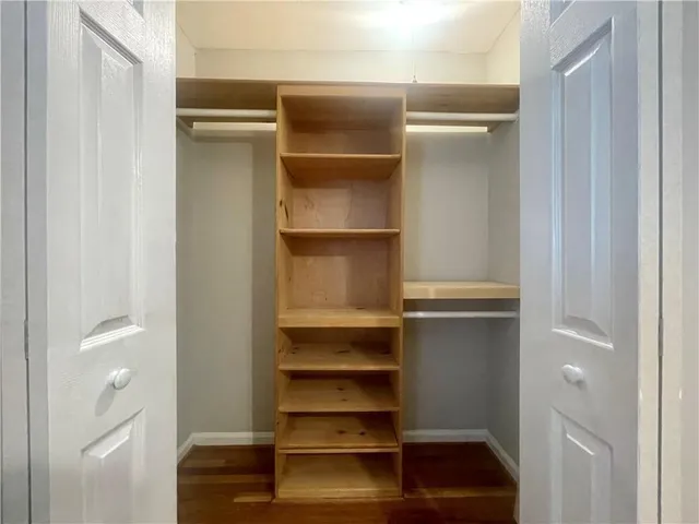 a view of walk in closet with empty racks