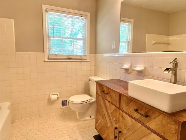 a bathroom with a sink toilet a mirror and window