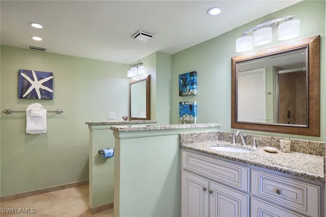 a bathroom with a granite countertop sink mirror and vanity