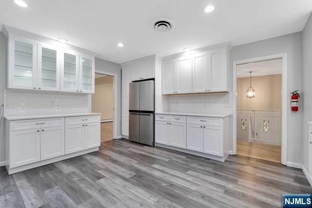 32 Rock Road Englewood Cliffs, NJ 07632 - Photo 5 of 30 a kitchen with white cabinets and wooden floors