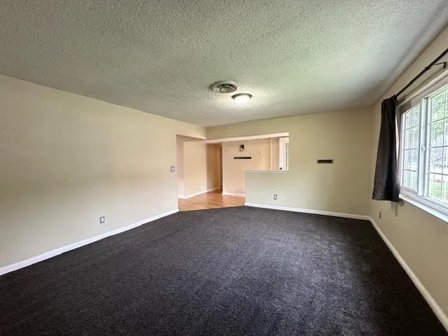 an empty room with windows and cabinet