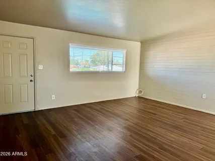 a view of a room with wooden floor and window