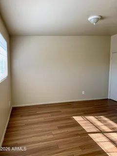 a view of empty room with wooden floor