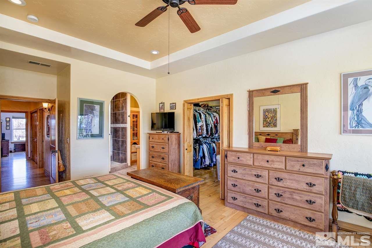 3500 South Allen Road Fallon, NV 89406 - Photo 22 of 40 a bedroom with a bed a dresser and a chandelier