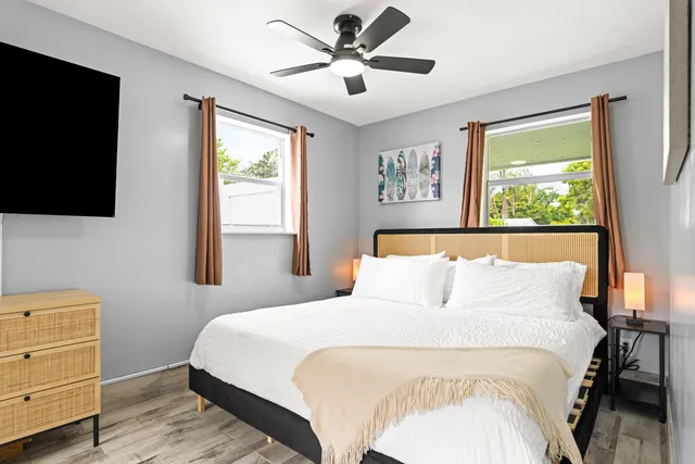 a bedroom with a large bed and a flat tv screen on dresser