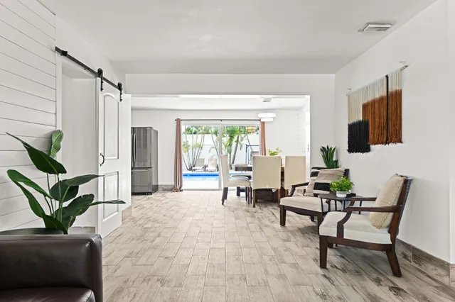 a living room with furniture a flat screen tv and a potted plant