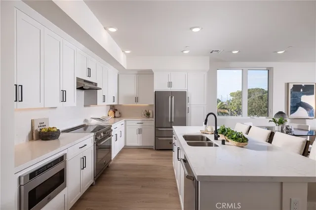 a kitchen with white cabinets and stainless steel appliances