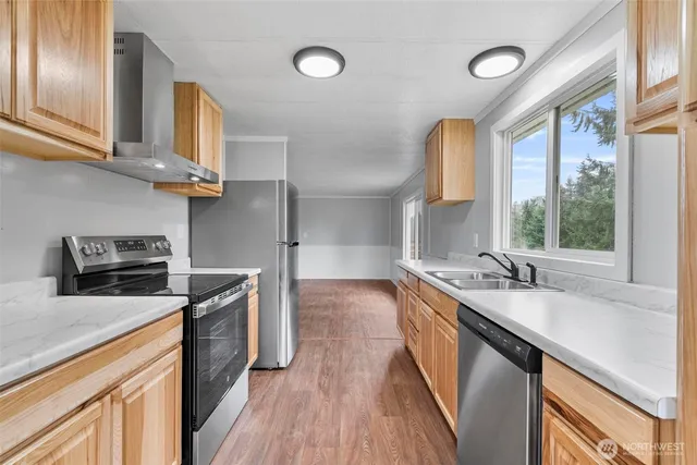 a kitchen with granite countertop a sink a counter space appliances and cabinets