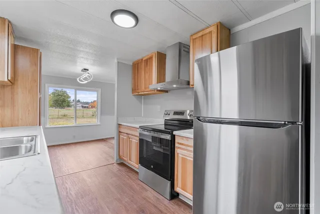 a kitchen with a refrigerator a stove and wooden cabinets