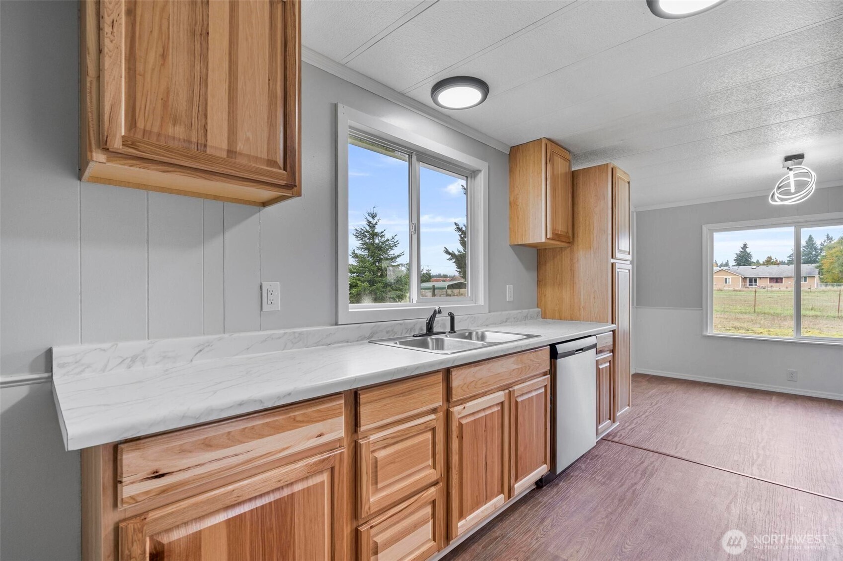 8826 183rd Avenue Southwest Rochester, WA 98579 - Photo 9 of 31 a kitchen with stainless steel appliances granite countertop a sink dishwasher and cabinets with wooden floor