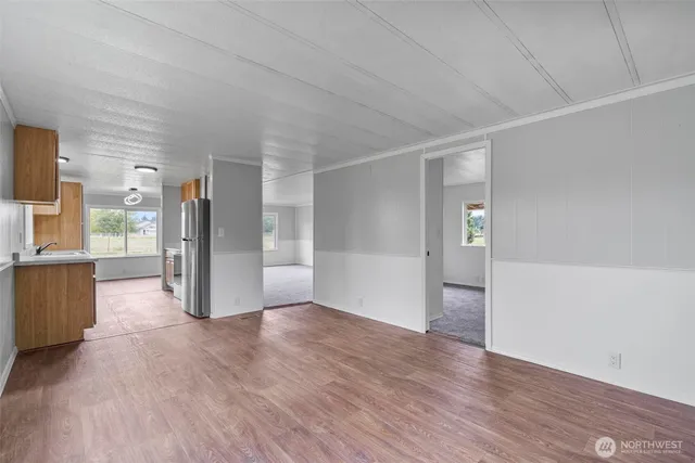 a view of a big room with wooden floor and windows