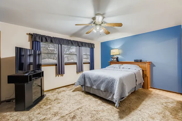 a bedroom with a large bed and a flat tv screen on dresser