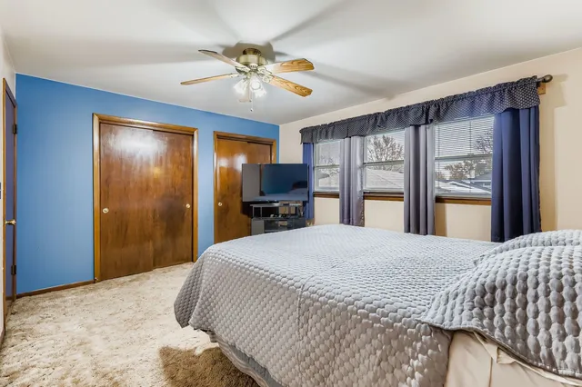 a bedroom with a large bed and a chandelier