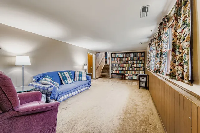 a living room with furniture and a book shelf