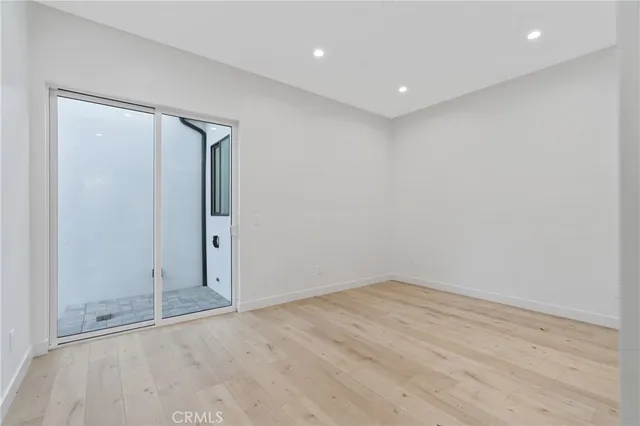an empty room with wooden floor and sliding door