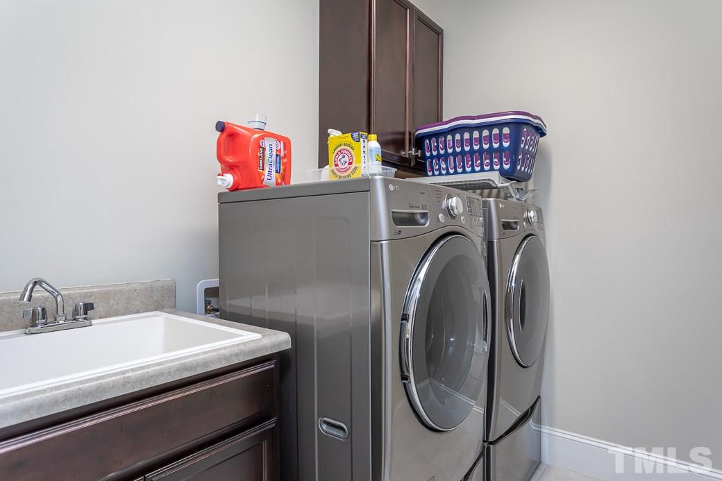 4604 Pleasant Pointe Way Raleigh, NC 27613 - Photo 25 of 30 Second floor laundry with utility sink and cabinetry