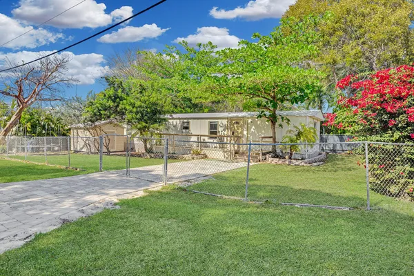 a view of backyard of house with green space