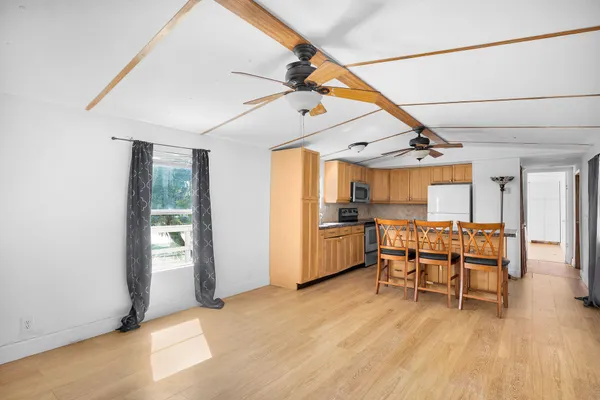 a view of a kitchen with furniture and wooden floor
