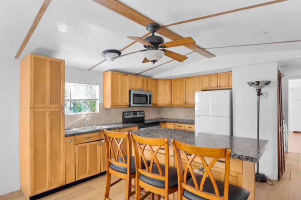 a kitchen with stainless steel appliances granite countertop a refrigerator and microwave
