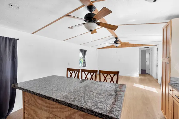 a view of a big room with wooden floor and windows