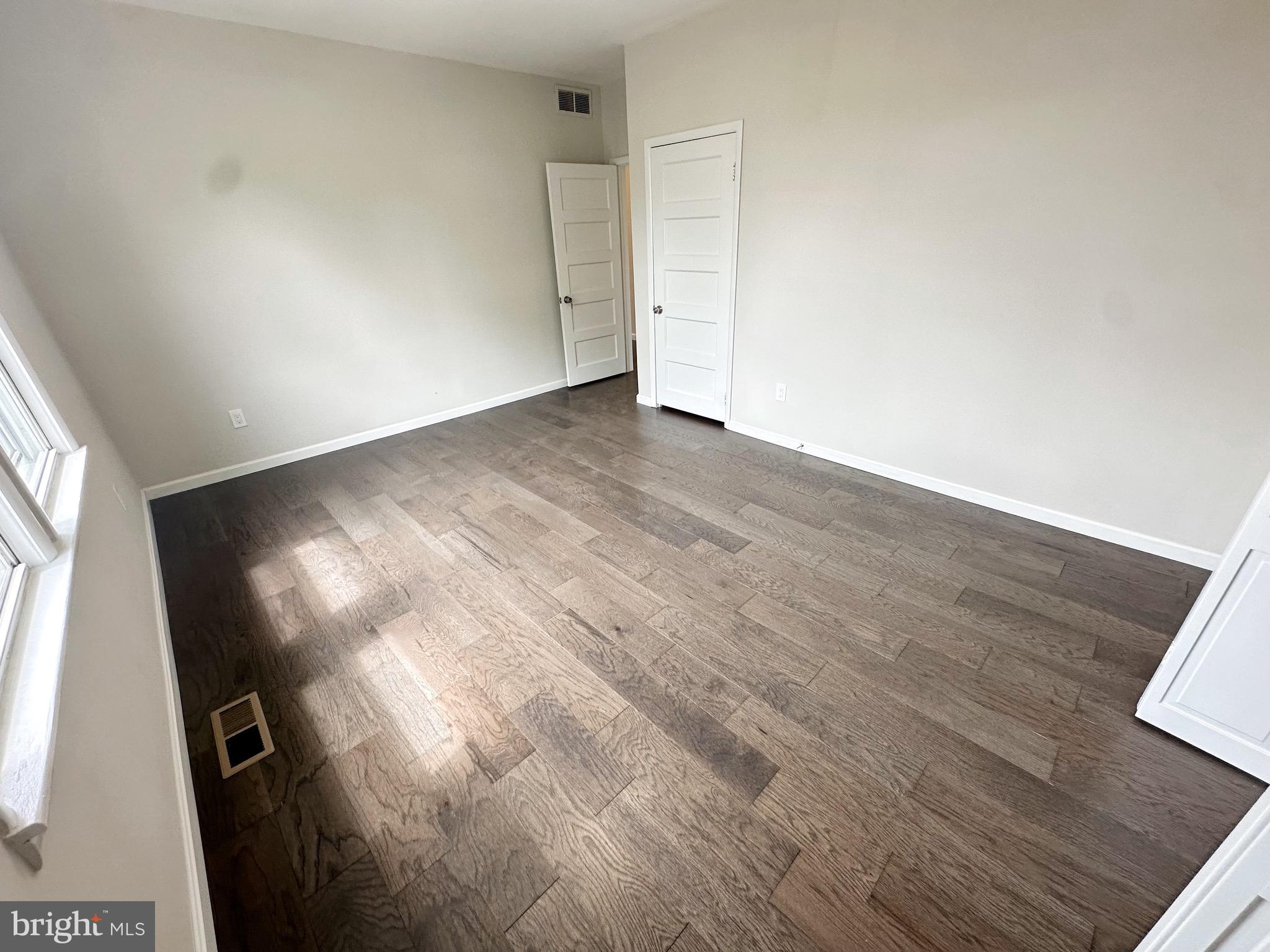 603 Brookwood Road Baltimore, MD 21229 - Photo 14 of 33 a view of an empty room with wooden floor and a window