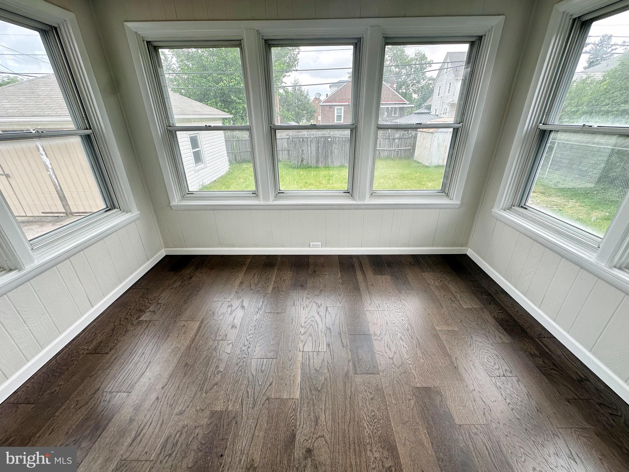 603 Brookwood Road Baltimore, MD 21229 - Photo 16 of 33 an empty room with wooden floor and windows