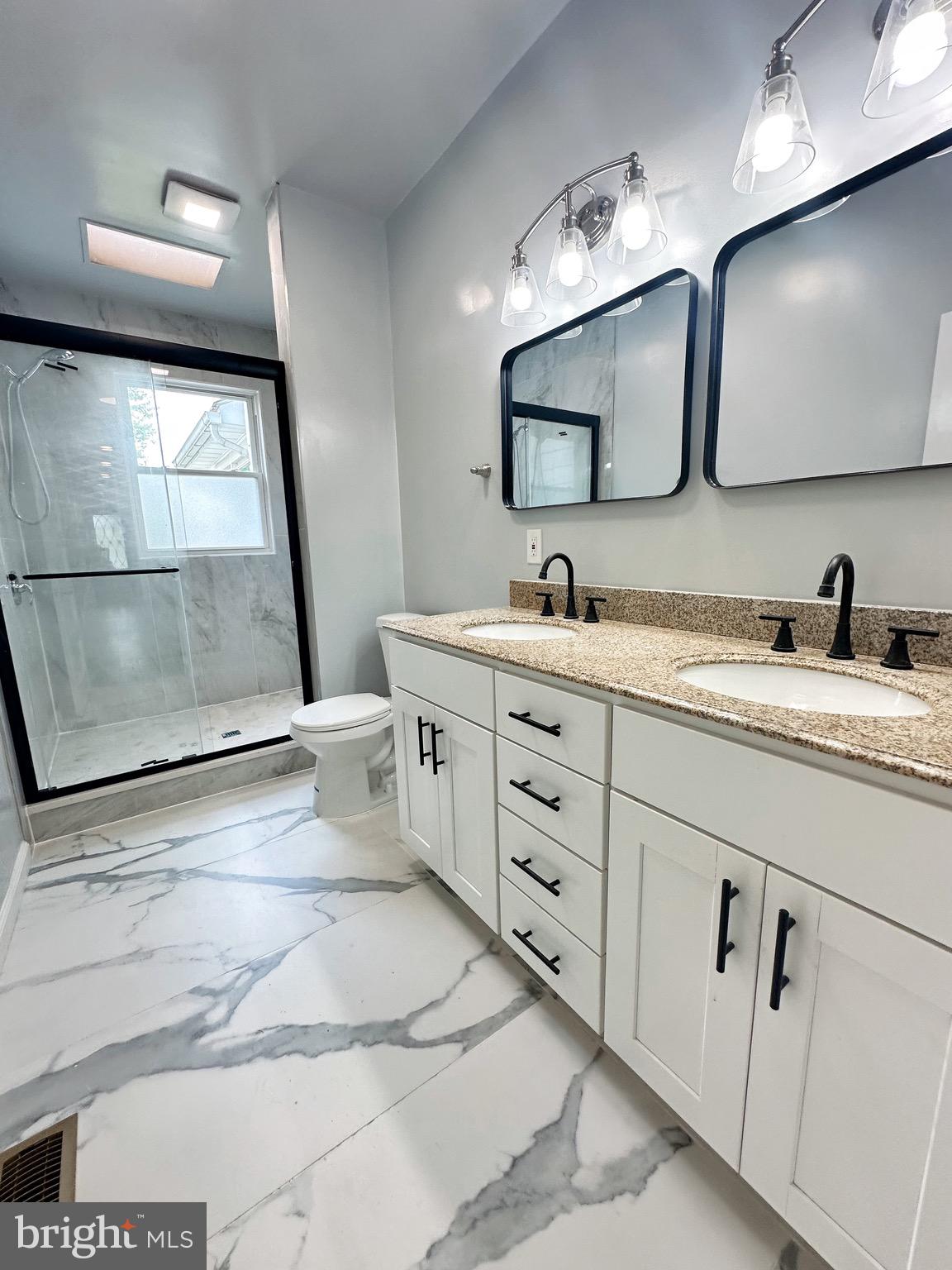 603 Brookwood Road Baltimore, MD 21229 - Photo 25 of 33 a bathroom with a double vanity sink and mirror