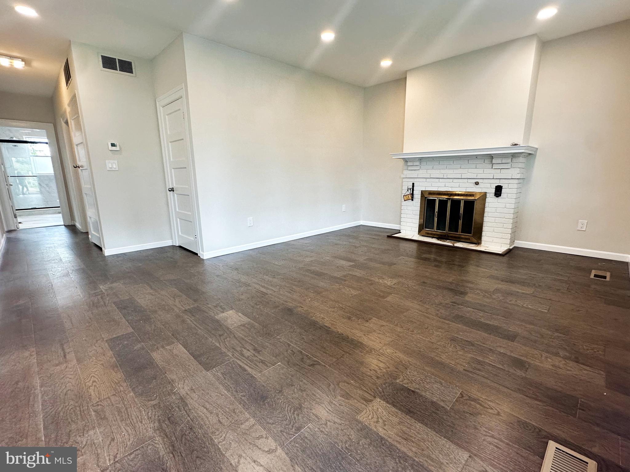603 Brookwood Road Baltimore, MD 21229 - Photo 5 of 33 a view of an empty room with wooden floor and a fireplace