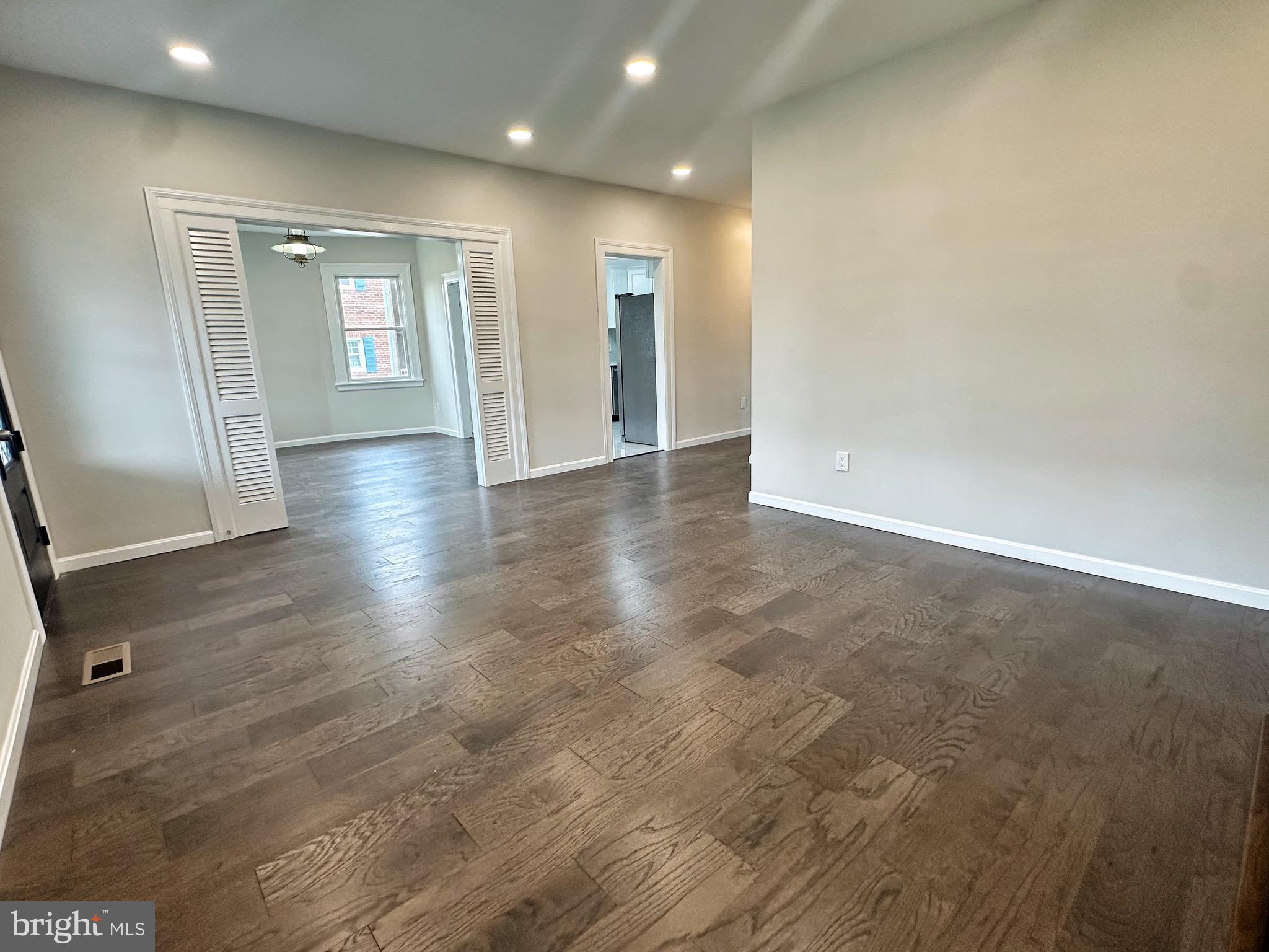 603 Brookwood Road Baltimore, MD 21229 - Photo 6 of 33 an empty room with wooden floor and windows