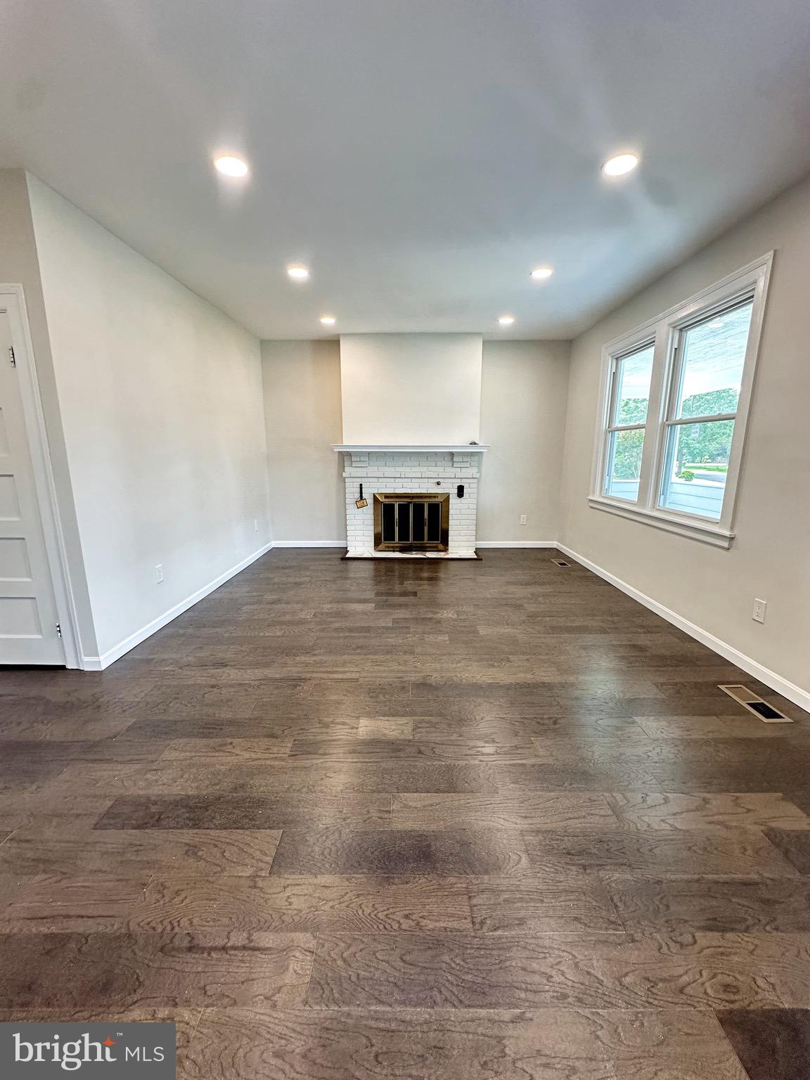 603 Brookwood Road Baltimore, MD 21229 - Photo 8 of 33 an empty room with wooden floor and windows