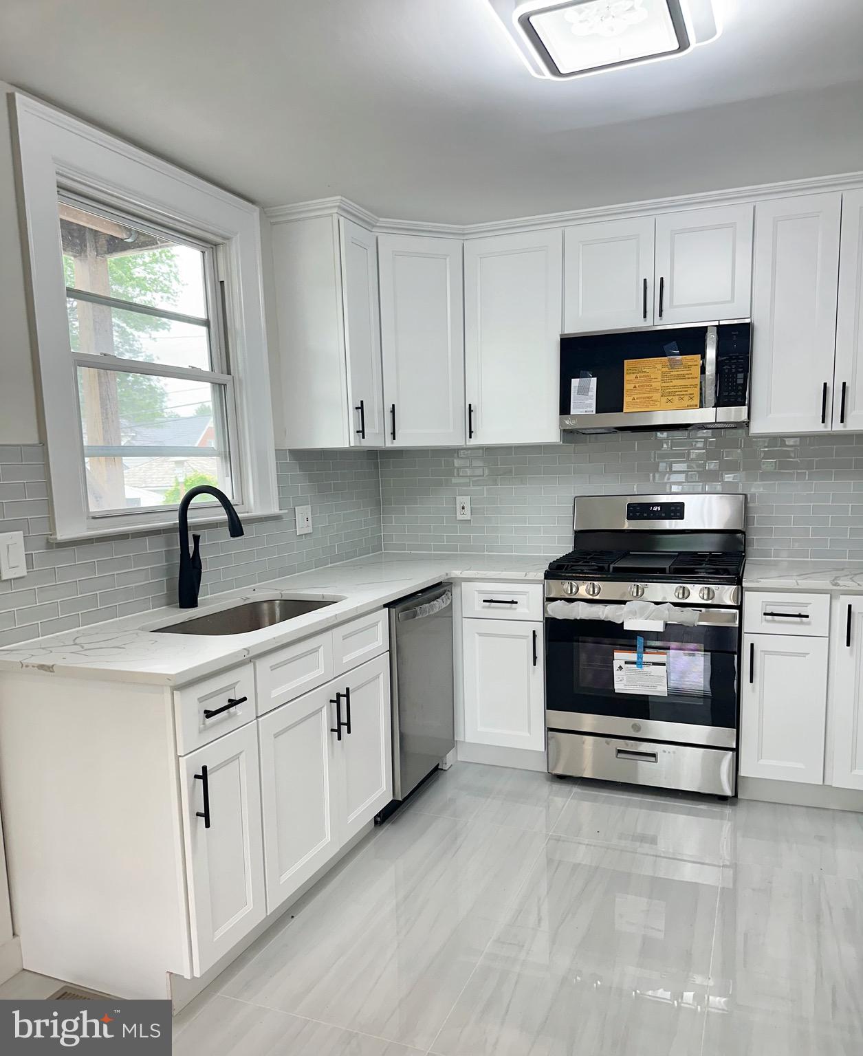 603 Brookwood Road Baltimore, MD 21229 - Photo 9 of 33 a kitchen with white cabinets and appliances