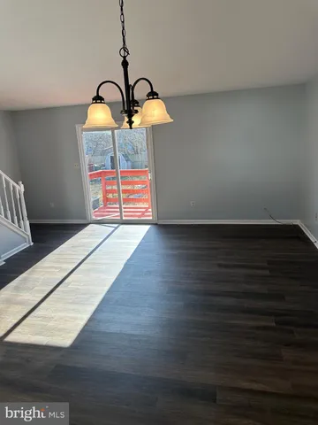 a view of a livingroom with wooden floor and staircase