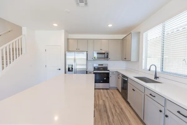 a kitchen with a sink a counter top space stainless steel appliances and cabinets