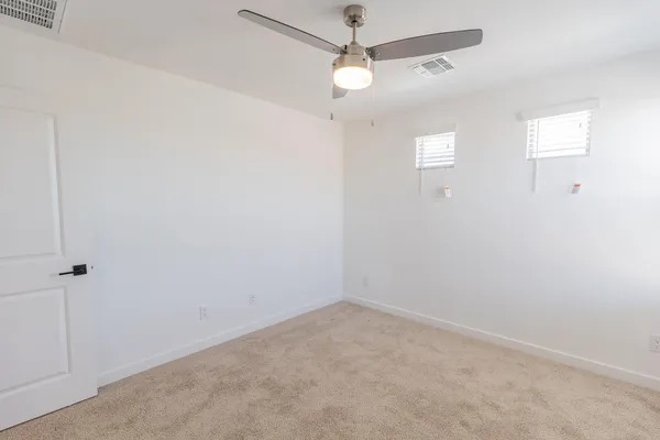 an empty room with a window and a fan