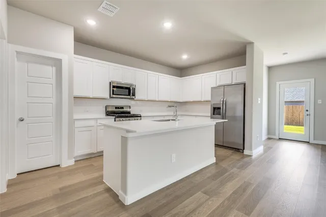 a kitchen with a refrigerator and a stove top oven