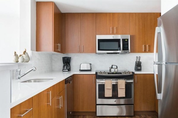 a kitchen with stainless steel appliances a microwave a sink and cabinets