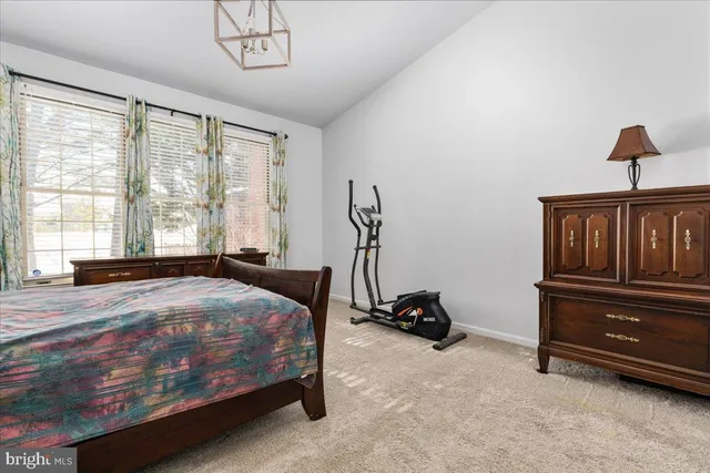 a bedroom with a bed a dresser and a window