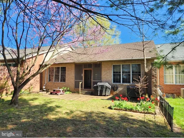 a front view of a house with a yard outdoor seating and covered with trees