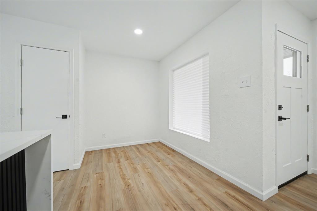 11446 Lippitt Avenue Dallas, TX 75218 - Photo 14 of 26 an empty room with wooden floor and windows