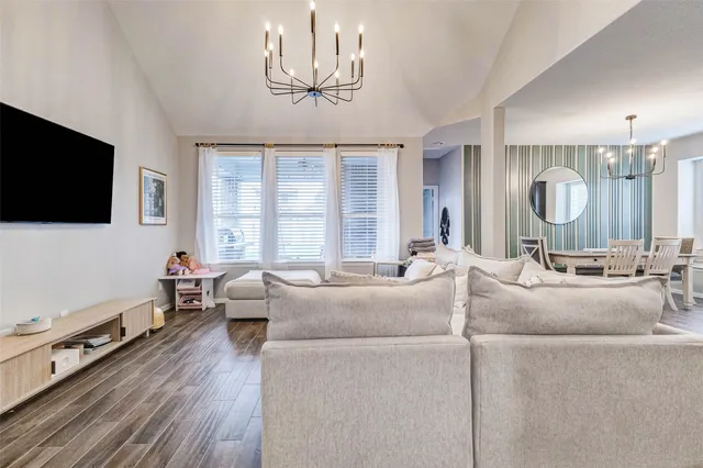 a living room with furniture a flat screen tv and a large window