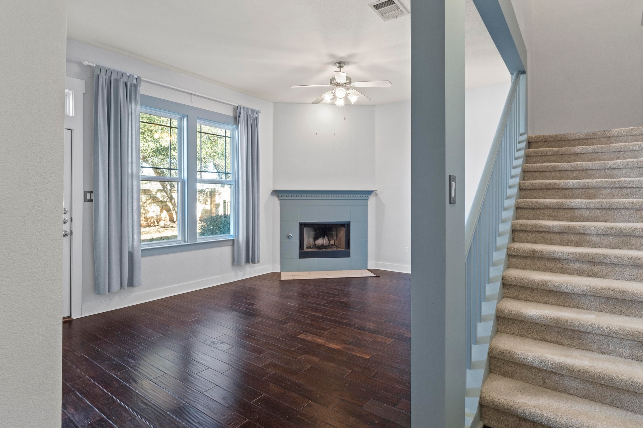 2930 Grand Oaks Loop, Unit 603 Cedar Park, TX 78613 - Photo 11 of 29 living room featuring dark wood-style floors, a ceiling fan, and a tile fireplace