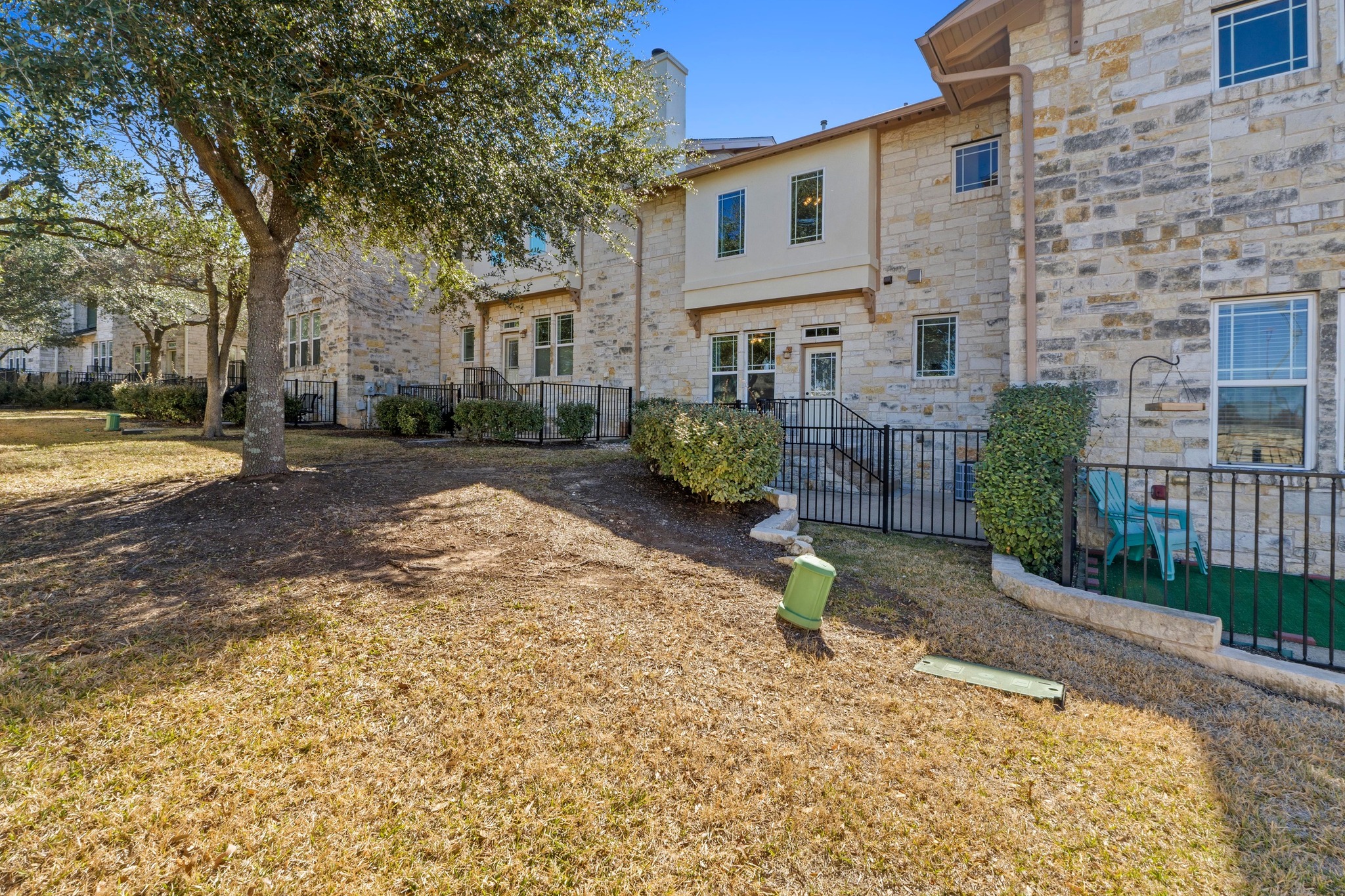 2930 Grand Oaks Loop, Unit 603 Cedar Park, TX 78613 - Photo 28 of 29 Rear view of house with stone siding and a chimney