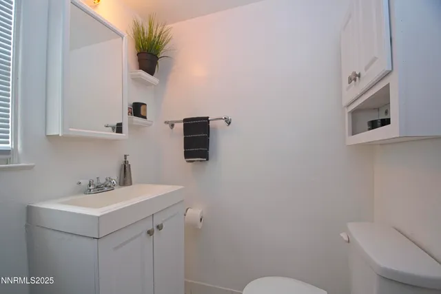 a bathroom with a sink a toilet and mirror