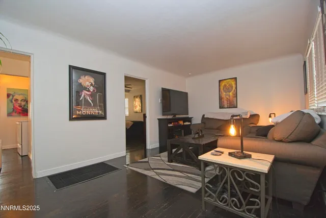 a living room with furniture a flat screen tv and a window