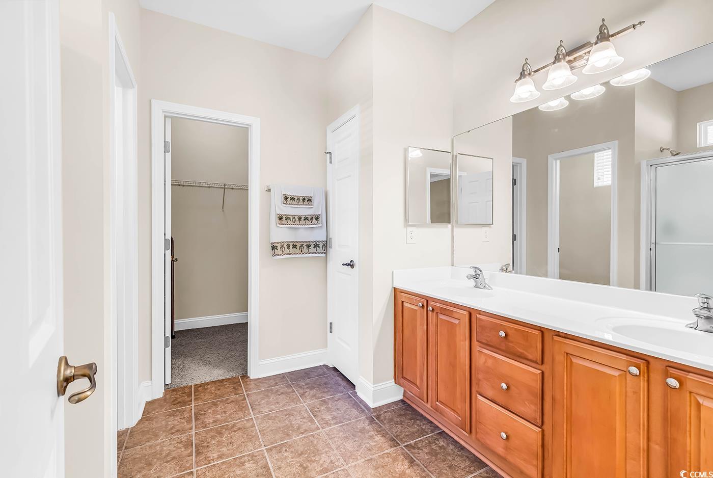 641 Botany Loop, Unit 63 Murrells Inlet, SC 29576 - Photo 18 of 40 Full bath featuring a stall shower, double vanity, a walk in closet, and dark tile patterned floors