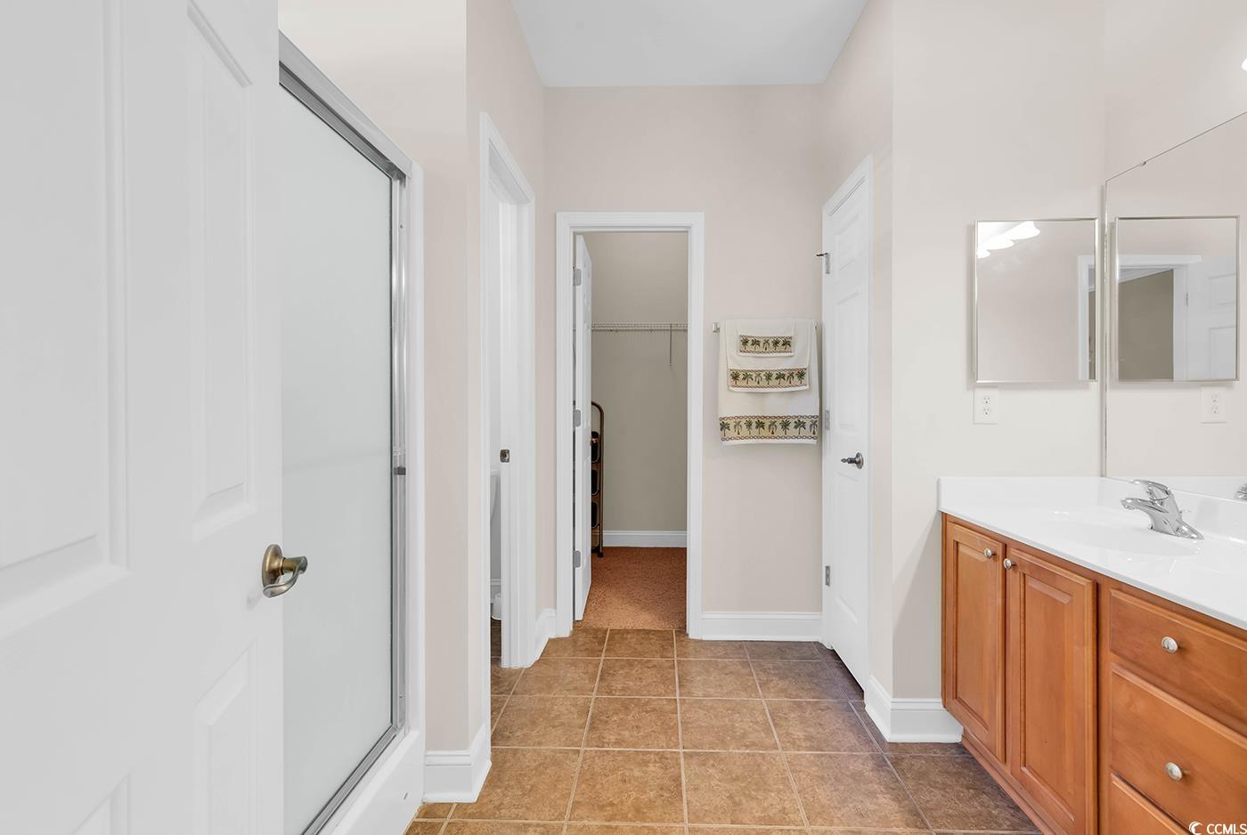 641 Botany Loop, Unit 63 Murrells Inlet, SC 29576 - Photo 19 of 40 Bathroom with a shower stall, vanity, light tile patterned floors, and a spacious closet