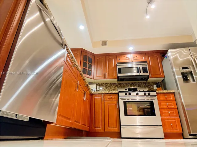 a kitchen with microwave a stove and cabinets