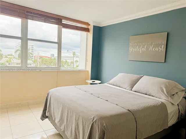 a bedroom with a bed and a large window